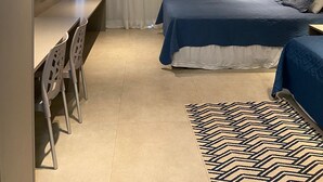 A modern bedroom with a bed, a desk, and a TV. - Flat Eco Resort Praia dos Carneiros (Tamandaré)