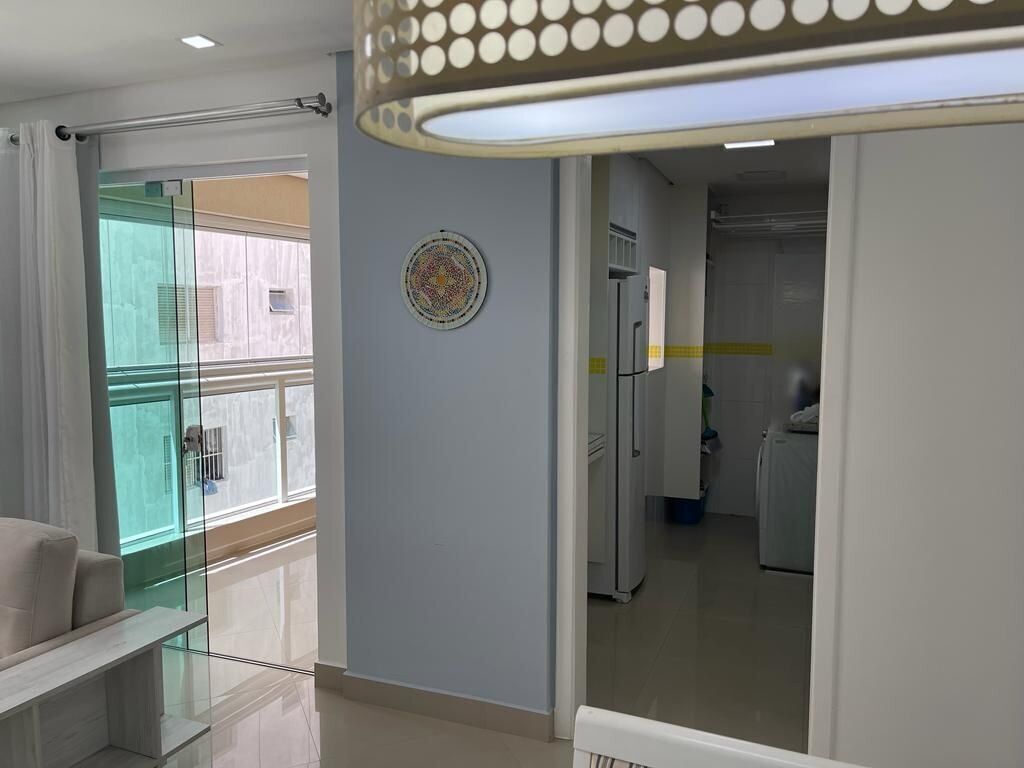 Una sala de estar moderna con un separador de vidrio, un sofá y una lámpara en el techo.