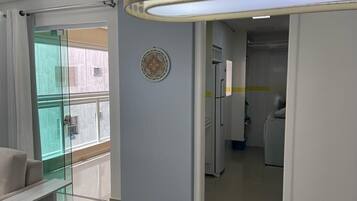 Una sala de estar moderna con un separador de vidrio, un sofá y una lámpara en el techo.