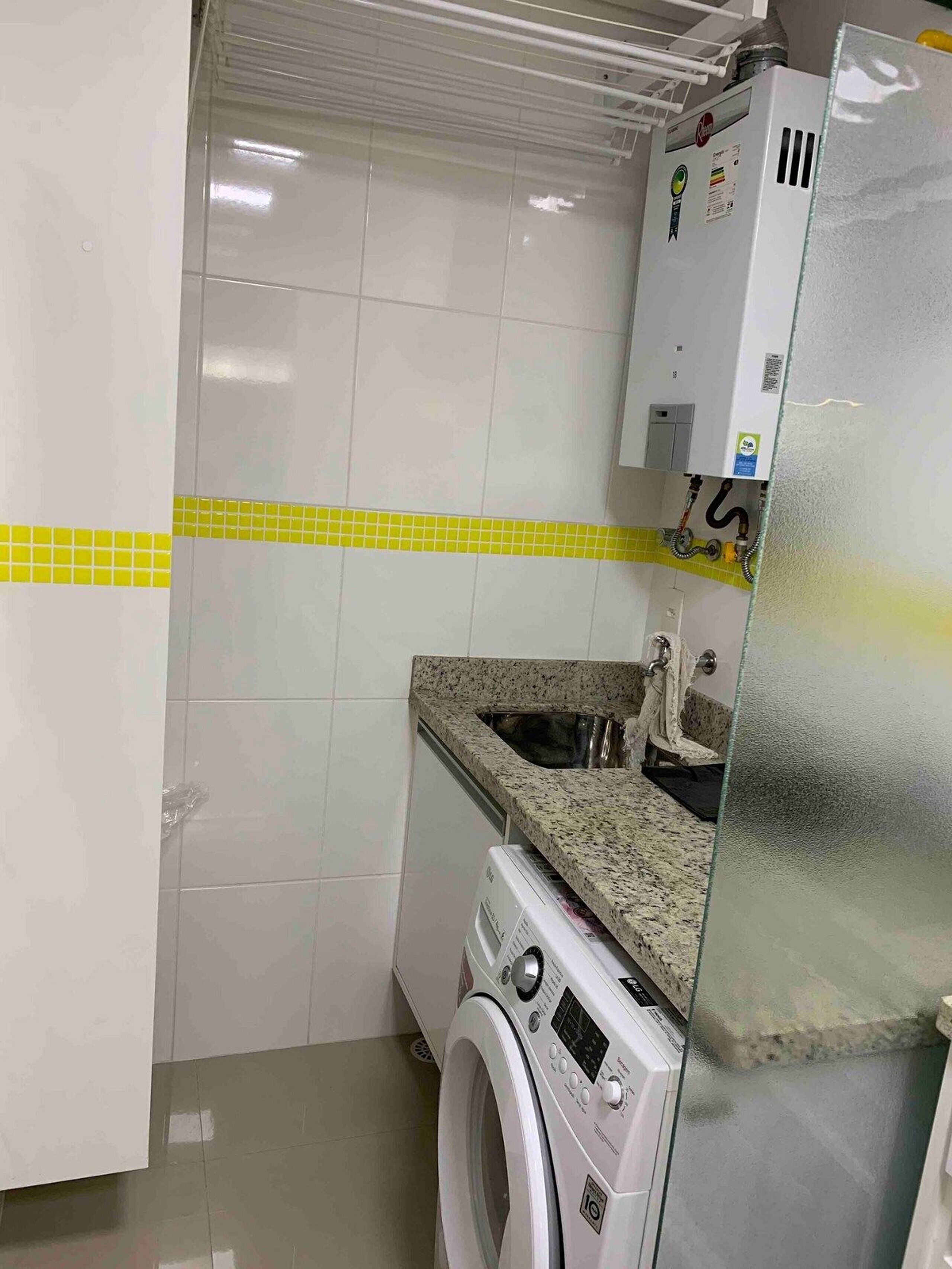Una cocina compacta con lavadora, lavaplatos y refrigerador.