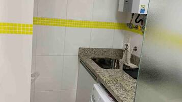 Una cocina compacta con lavadora, lavaplatos y refrigerador.