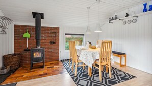 A cozy room with a brick fireplace, wooden dining table, and chairs.