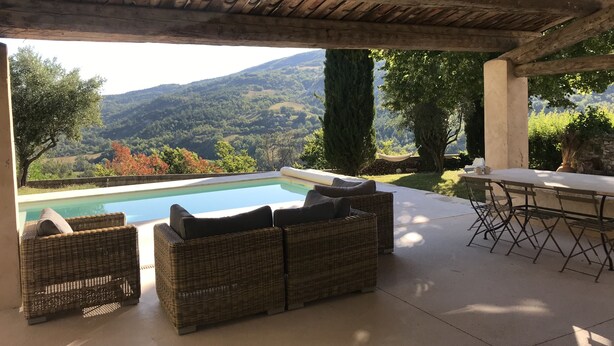 An outdoor seating area with wicker furniture, a pool, and a view of the countryside. - Large country house in a village in the Lubéron park, Forcalquier country (Limans)