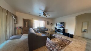 A spacious living room with a sofa, a coffee table, and a television.