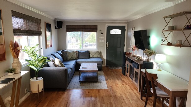 Un salon chaleureux avec un canapé d’angle, une table basse et un coin repas comprenant une table et des chaises.