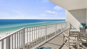 Un balcon avec vue sur une plage et l’océan.