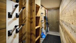 A ski storage area with racks for skis and a blue bag.