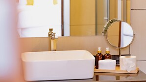 A bathroom with a white sink, a mirror, and toiletries on the counter. - La Casona de Josefa (Querétaro)