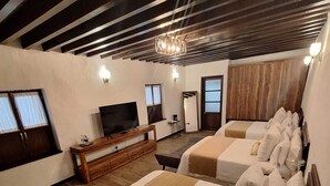 A hotel room with two beds, a TV, a wooden cabinet, and a large mirror. - La Casona de Josefa (Querétaro)