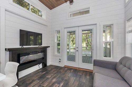 Park Model TinyHome with spacious front porch table outdoor furniture and spa.