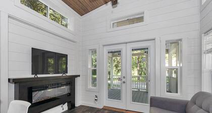 Park Model TinyHome with spacious front porch table outdoor furniture and spa.