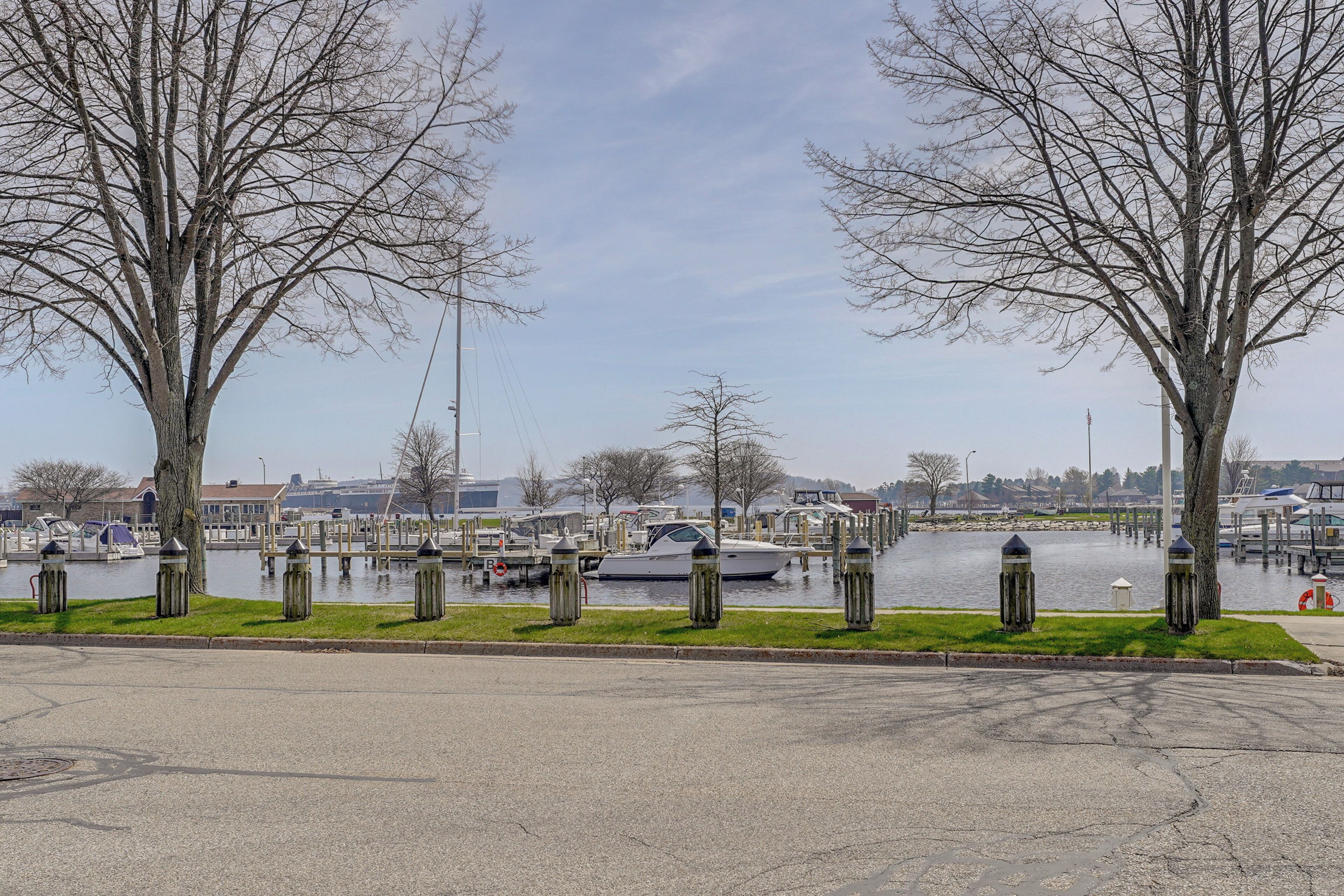 Une vue sur le front de mer, avec un port de plaisance, des bateaux et des arbres le long de la rive.