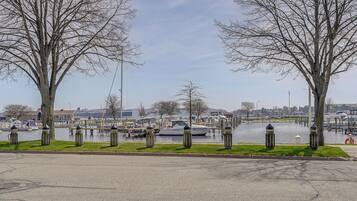 Une vue sur le front de mer, avec un port de plaisance, des bateaux et des arbres le long de la rive.