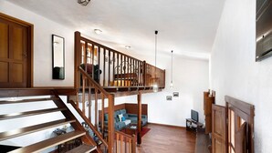 A wooden staircase leading to a loft bedroom with a view of the city. - Chalet 'La Higuera' with Sea View, Shared Terrace and Wi-Fi (Frontera)