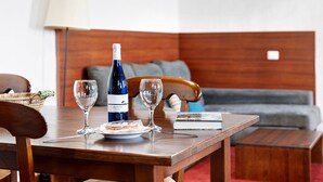 A wooden table with a wine bottle, two glasses, a plate, and a book. - Chalet 'La Higuera' with Sea View, Shared Terrace and Wi-Fi (Frontera)