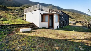 A small, modern house with a balcony, surrounded by a mountainous landscape. - Chalet 'La Higuera' with Sea View, Shared Terrace and Wi-Fi (Frontera)
