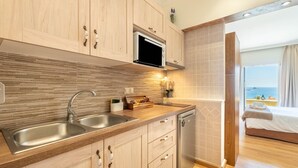 A modern kitchen with wooden cabinets, a microwave, and a dishwasher. - Studio Apartment "Angela 4" with Sea View, Shared Pool & Wi-Fi (Corfu)
