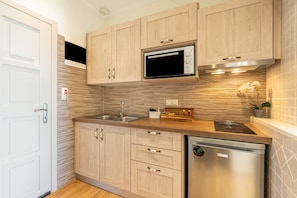 Una cocina moderna con armarios de madera, un microondas, un fregadero y un lavavajillas.