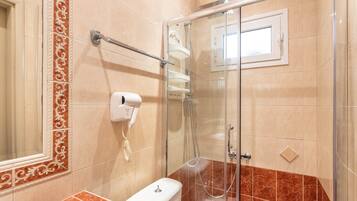 Ein Badezimmer mit Duschkabine, Toilette und Handtuchhalter.