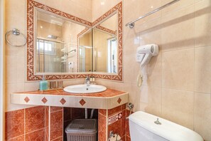 Ein Badezimmer mit Waschbecken, Spiegel, Toilette und Fön.
