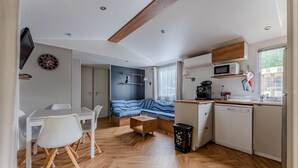 A compact kitchen with a microwave, sink, and wooden cabinets.