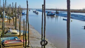 Un río con barcos amarrados a la orilla, una playa arenosa y un cielo despejado.