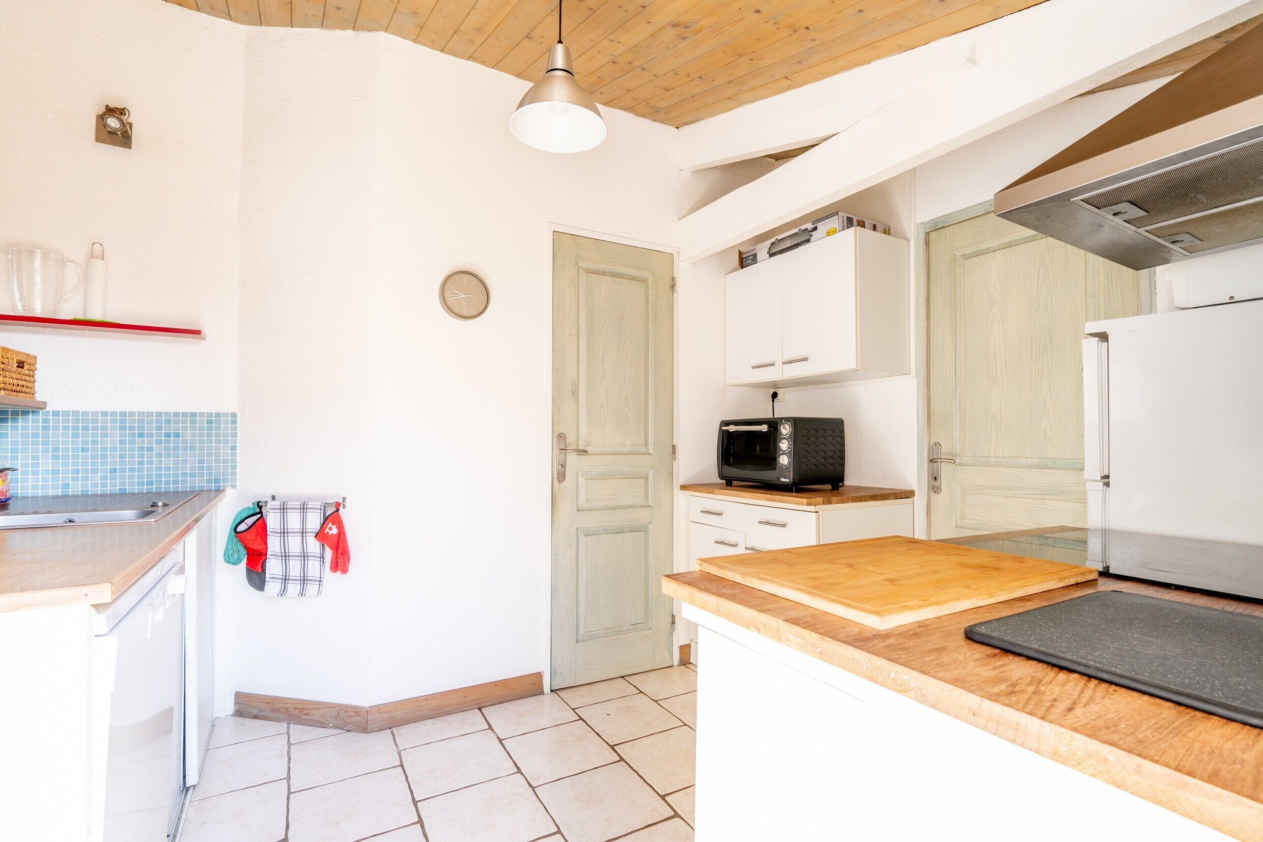 A kitchen with white cabinets, a microwave, and a wooden countertop.