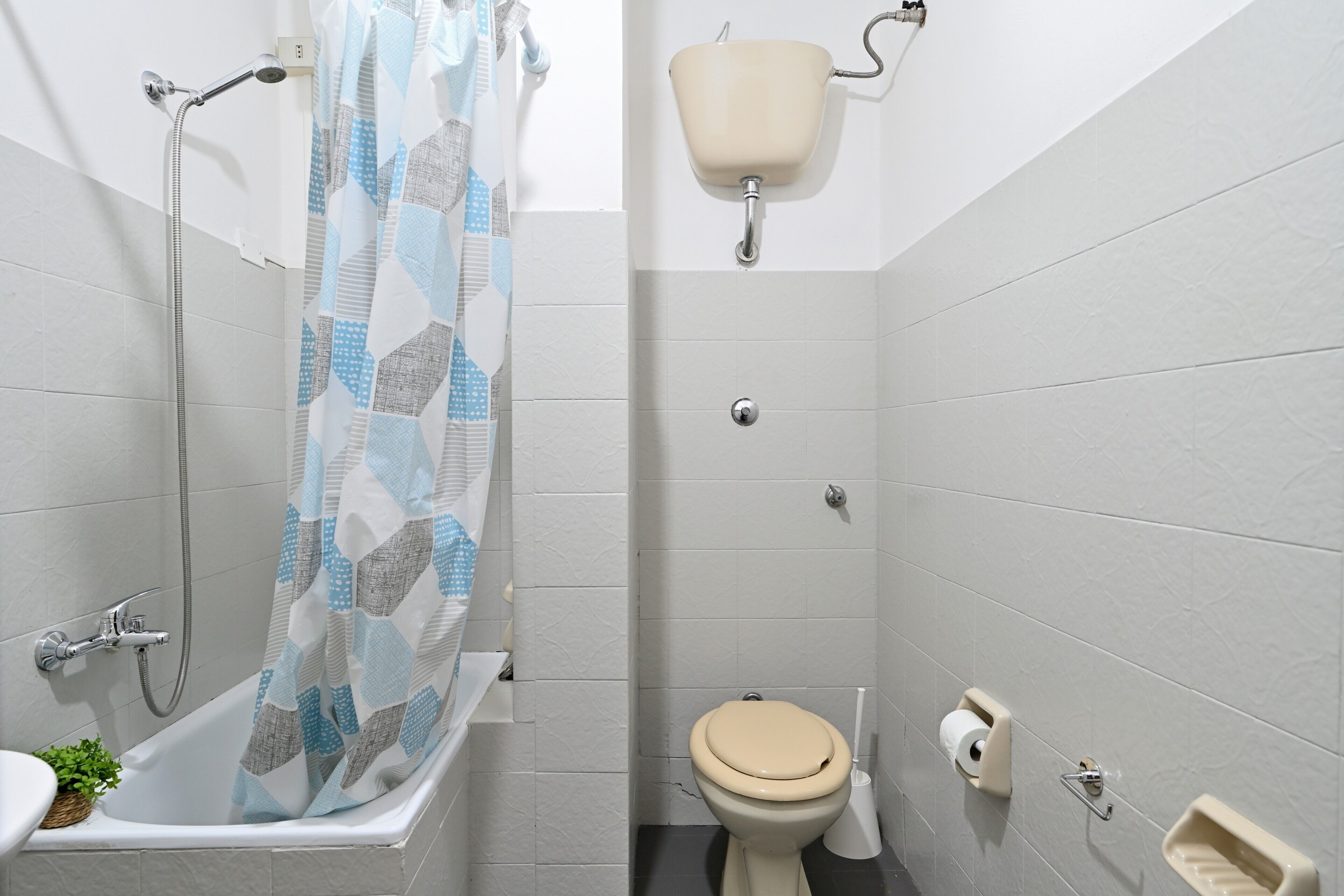 A bathroom with a shower, toilet, and sink.