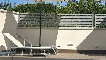 Ein Schwimmbecken mit Sonnenschirm, Tisch und Bank.
