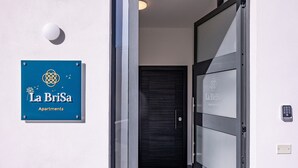 Un letrero azul con 'La BriSa Apartments' y una puerta con cerradura electrónica.