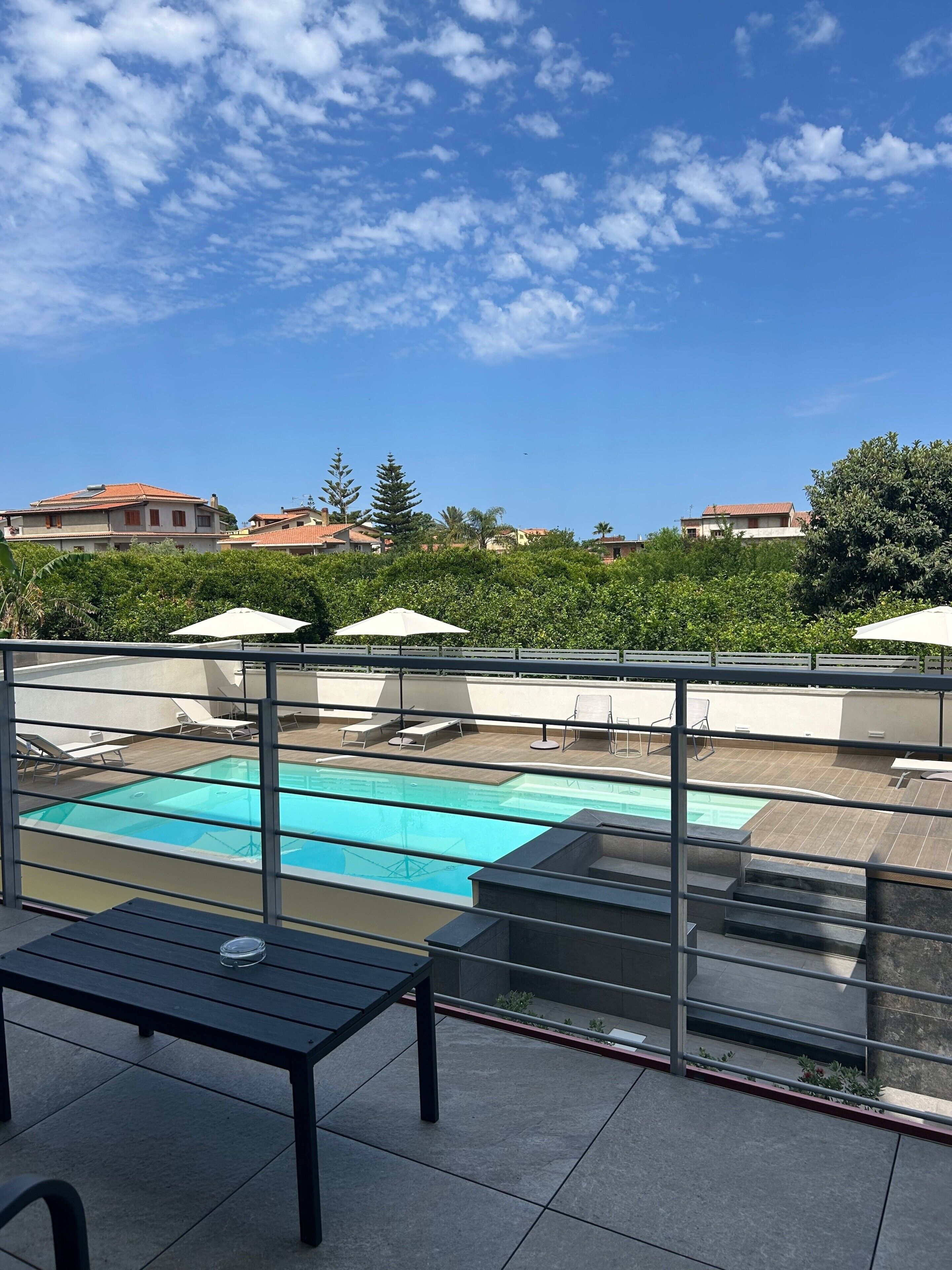 Ein Poolbereich auf dem Dach mit freiem Blick zum Himmel, einem Pool und den umliegenden Gebäuden.