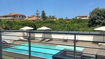 Ein Poolbereich auf dem Dach mit freiem Blick zum Himmel, einem Pool und den umliegenden Gebäuden.