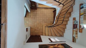 Una escalera de caracol con un muro de azulejos y un cuadro en la plataforma.