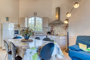 Une cuisine compacte comprenant un coin repas, un four à micro-ondes, un évier et une cuisinière.