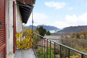 Un balcon avec vue sur les montagnes et un lac.