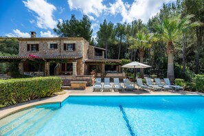 A stone villa with a pool, lounge chairs, and a covered patio. - Villa "Can Seguinot d'Alt" with Mountain View, Private Pool & Wi-Fi (pollensa)