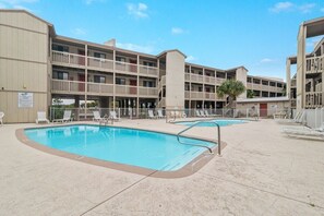 Un hôtel doté d’une piscine, de plusieurs balcons et d’un panneau indiquant qu’il accepte les animaux de compagnie.