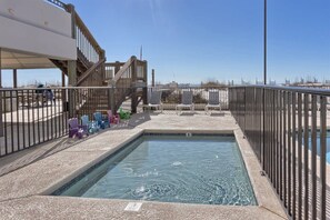 A swimming pool with a wooden deck and a metal fence. - Island Wind West 177, Next to Hangout, Beachfront (Gulf Shores)