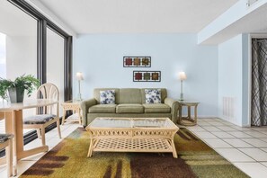 Ein Wohnzimmer mit einer Couch, einem Couchtisch und Sesseln. Darüber befinden sich zwei Wandbilder.
