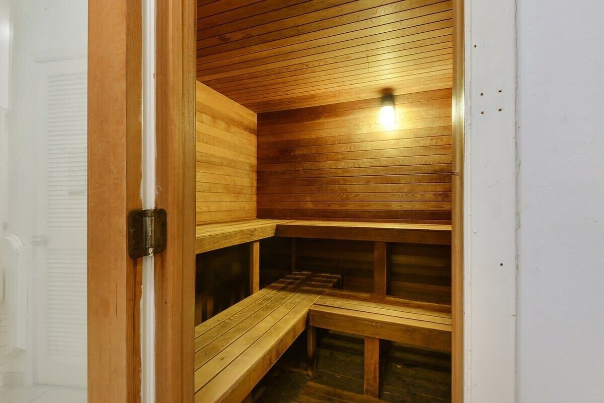 A sauna with wooden benches and a sloped ceiling.