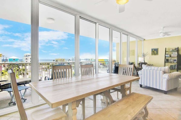 A spacious room with a large wooden table, chairs, and a sofa.