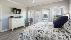 A bedroom with a bed, dresser, and a ceiling fan.
