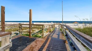 A wooden boardwalk leading to a beach with clear skies. - Regency Isle 806 | Gulffront Condo w/Stunning Views, Pools & Sauna (Orange Beach)
