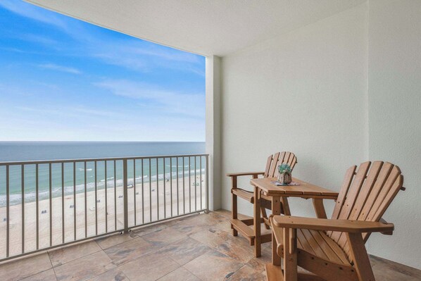 A balcony with a view of the beach and ocean.