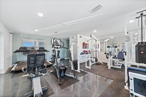 A gym with treadmills, elliptical machines, and weightlifting equipment.