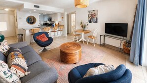 A modern living room with a sofa, a round coffee table, and a TV.