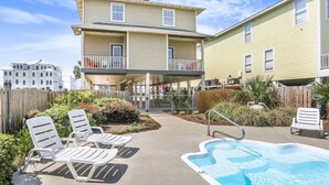 A two-story building with a swimming pool and lounge chairs. - Camp David Side B- pool, beach view (Gulf Shores)