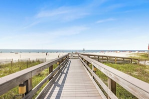 A wooden boardwalk leading to a sandy beach with a clear sky. - Pelican Pointe1204: 3BR/ 2BA, gulf-front. (Orange Beach)