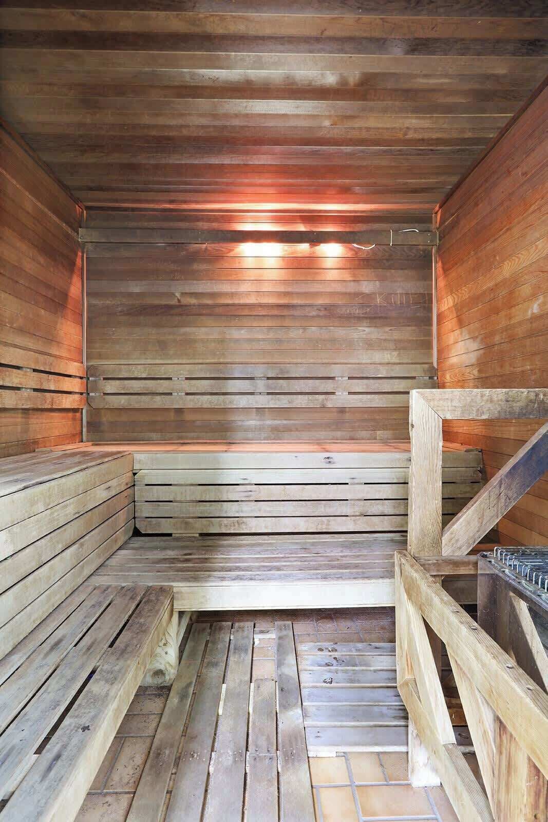 Una sauna con bancos de madera y suelo de baldosas.