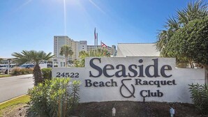 A sign for Seaside Beach & Racquet Club with a number 24522.